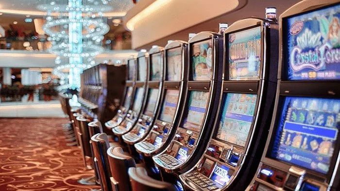 Rows of illuminated slot machines on a casino floor.